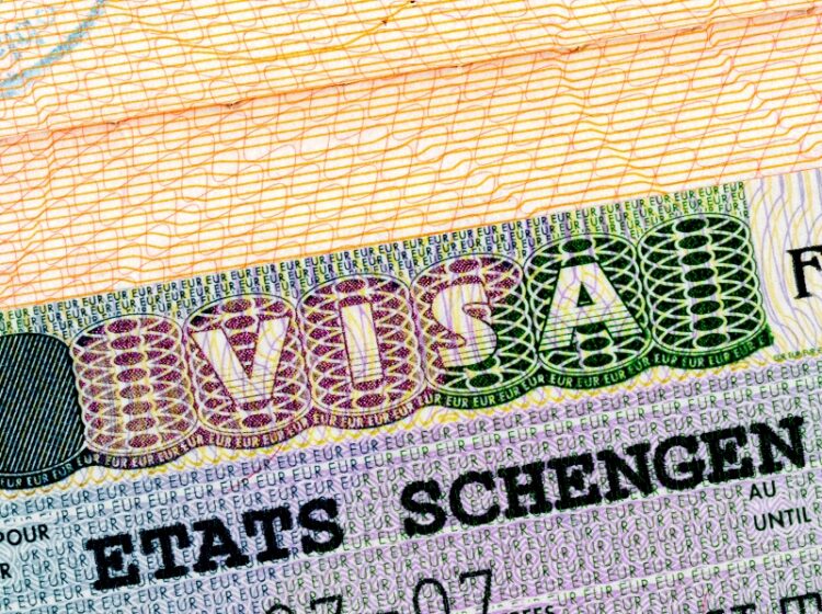 Schengen visa in passport closeup.