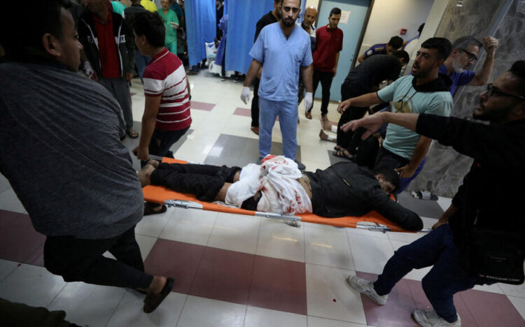 SENSITIVE MATERIAL. THIS IMAGE MAY OFFEND OR DISTURB    An injured person is assisted at Shifa Hospital after an Israeli air strike hit the nearby Al-Ahli Hospital, according to Gaza Health Ministry in Gaza City, Gaza Strip, October 17, 2023. REUTERS/Mohammed Al-Masri