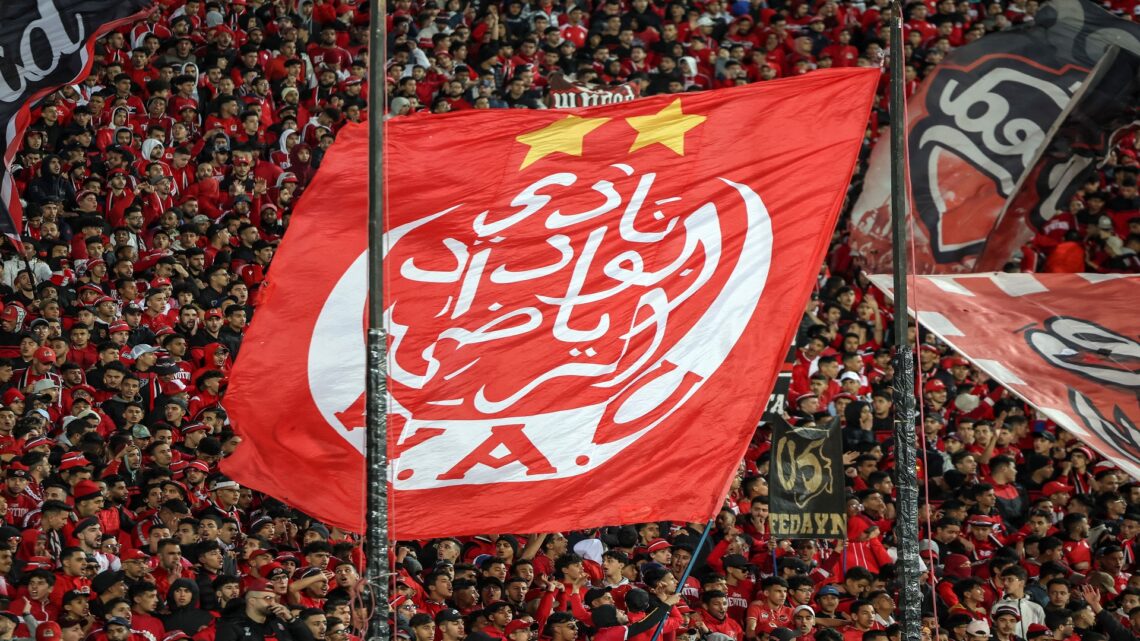 In this picture taken on January 25, 2023, Wydad Athletic Club supporters cheer during the Botola Pro 1 league football match between Wydad AC and MAS Fez at Stade Mohammed V in Casablanca. - When Morocco's "ultras" crowd into a football stadium, the fan groups' full-throated chants, spectacular pyrotechnics and sometimes more rowdy and anti-authoritarian antics often steal the show. Casablanca's stadium often roars with the chants of passionate supporters of the city's Wydad team as they raise coloured placards aloft to form a vast, moving mosaic that spells out their motto: "Free souls". (Photo by FADEL SENNA / AFP) (Photo by FADEL SENNA/AFP via Getty Images)