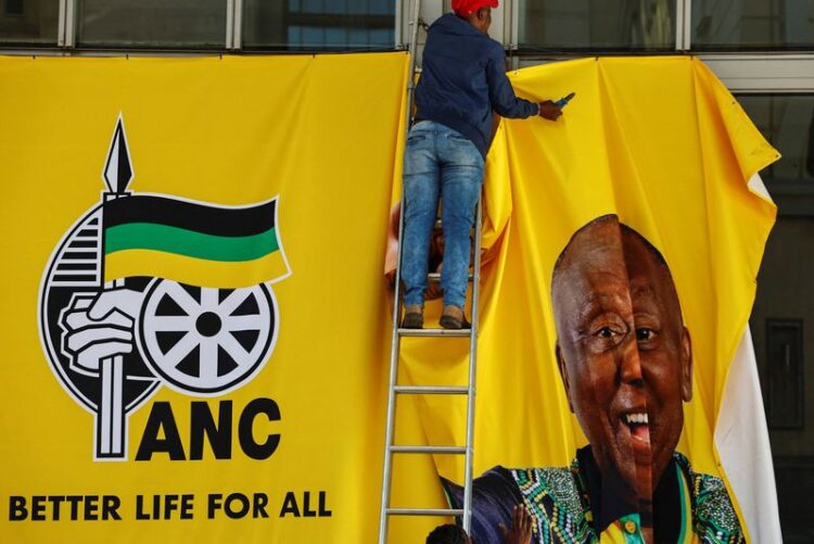 Un ouvrier enlève une bannière de campagne du président sud-africain Cyril Ramaphosa après une manifestation du Congrès national africain (ANC) en vue des prochaines élections à Sandton, Johannesburg. /Photo prise le 25 mai 2024/REUTERS/James Oatway