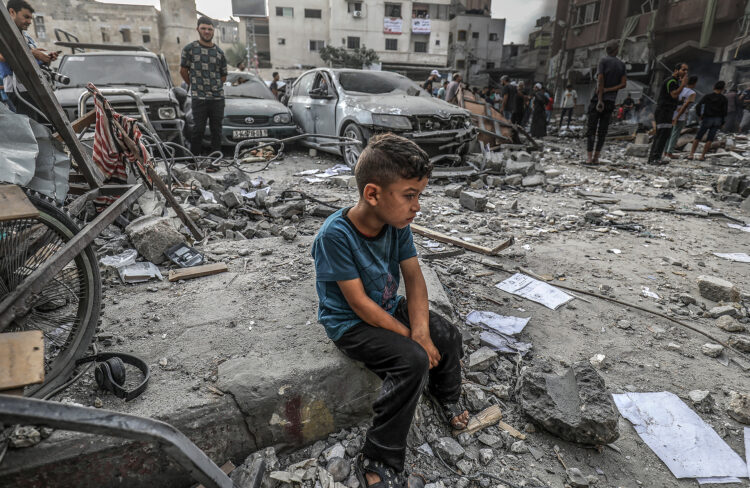 10 October 2023, Palestinian Territories, Khan Yunis: A Palestinian boy sits among the rubble of a destroyed building, following an Israeli air attack on Khan Yunis. The Israeli military said early Tuesday that it had retaken full control of the border with Gaza, after Hamas militants breached defences at the weekend and went on a rampage through nearby communities. Photo: Abed Rahim Khatib/dpa (Photo by Abed Rahim Khatib/picture alliance via Getty Images)