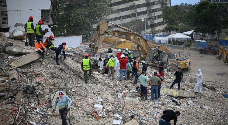Rescue teams and volunteers search for bodies amid the rubble of a collapsed building in Caraballeda, Venezuela, on August 3, 2026. (Photo by Federico PARRA / AFP)